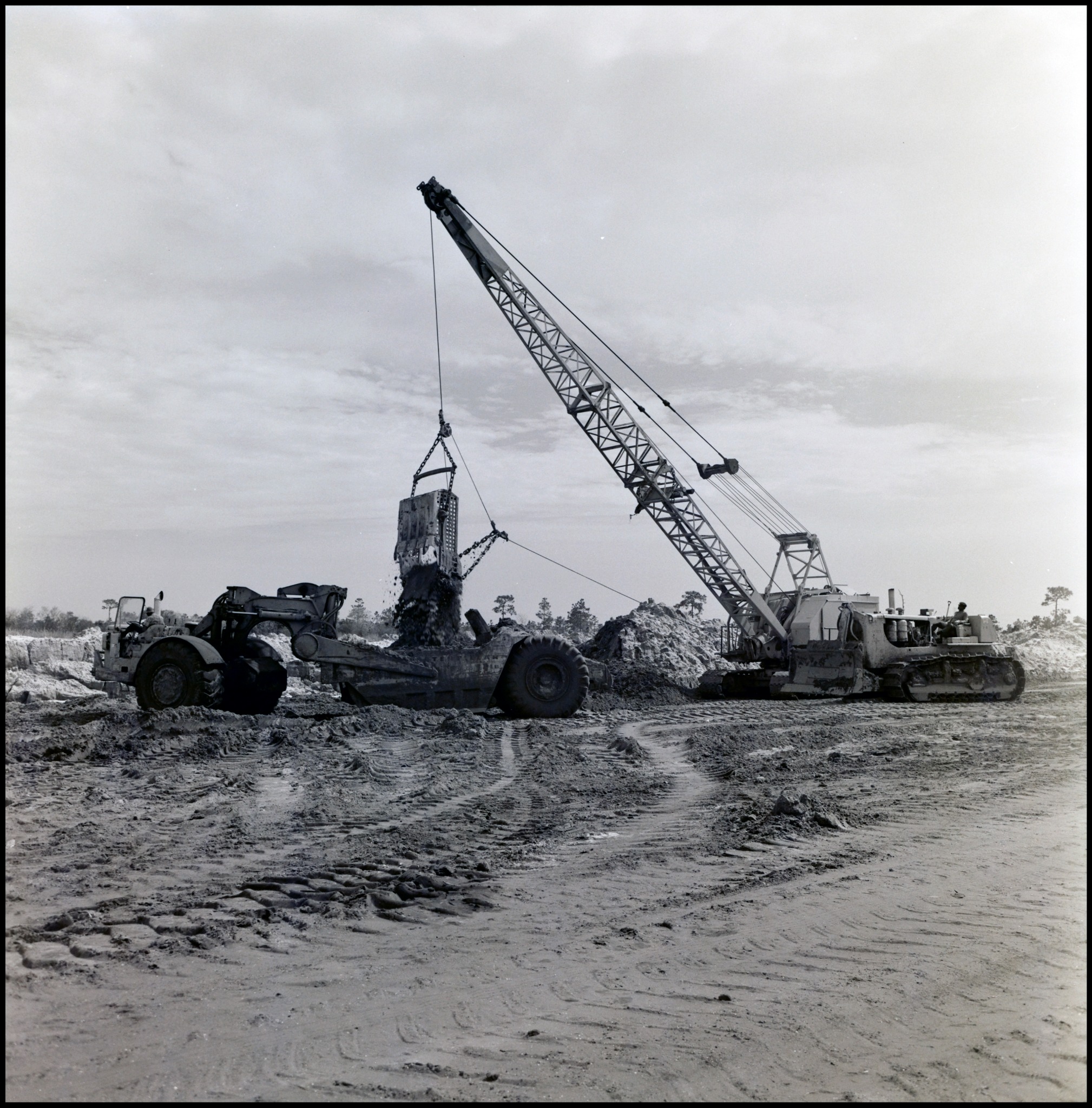 A dragline loading earth into a scraper