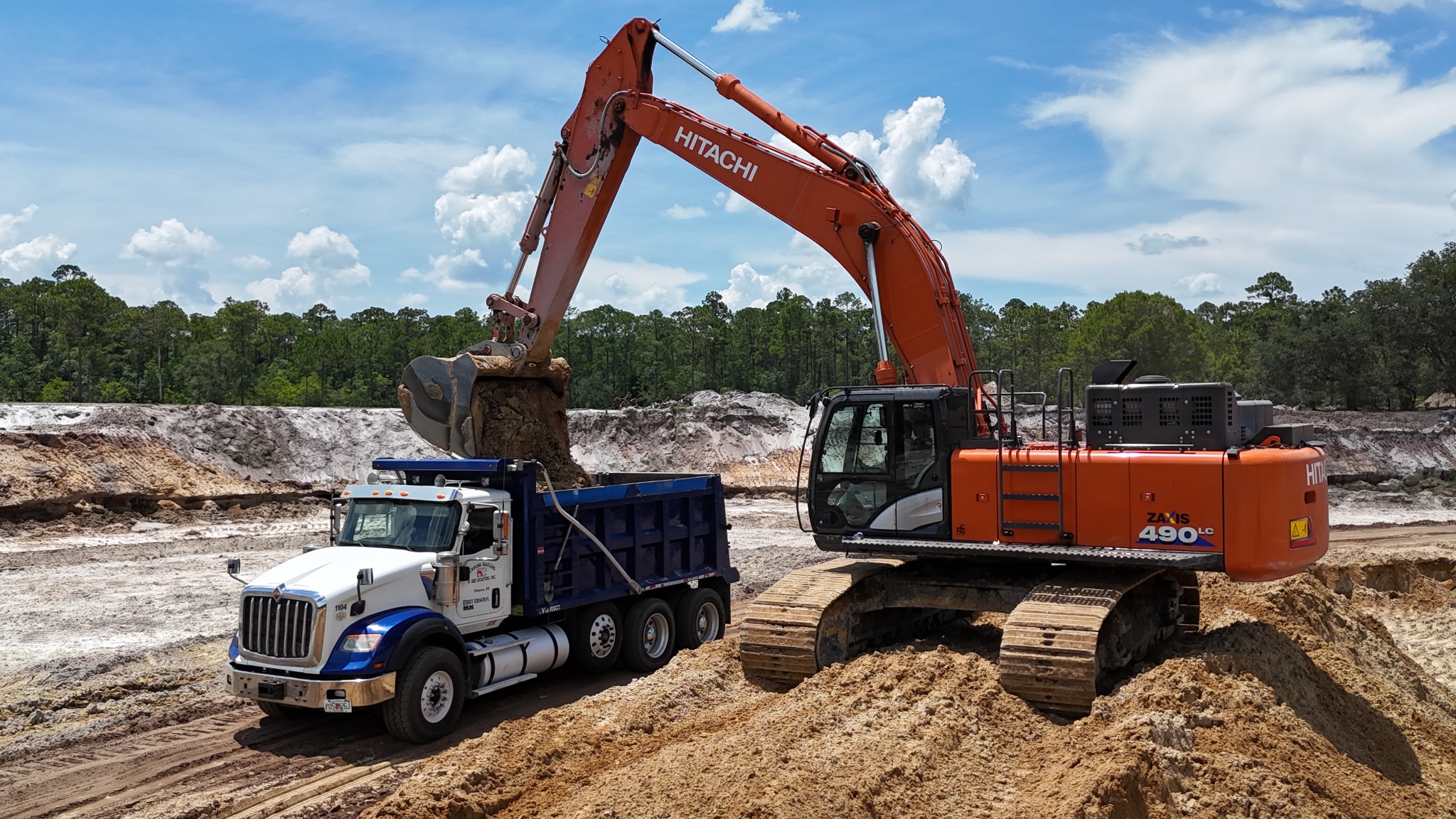 Hitachi excavator loading a dump truck with material at a Southern Materials Group jobsite